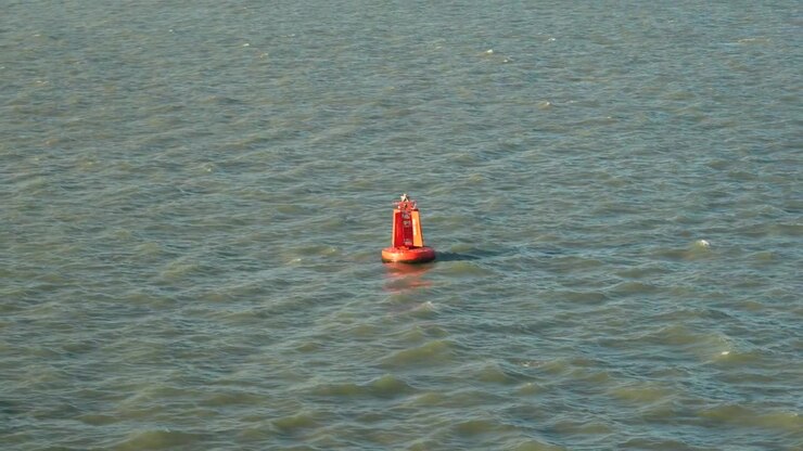 Red Port channel marker buoy. Coastal shipping channel navigation