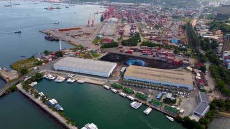 aerial panoramic high angle orbit establishes ferry pier in sihanoukville city with boats along coast, harbor landscape