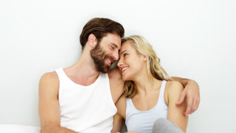 Cute-couple-sitting-on-a-bed-and-holding-each-other-