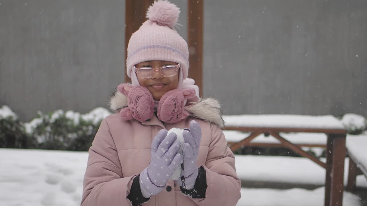 Menina Jovem Feliz Brincando com Bola de Neve no Inverno