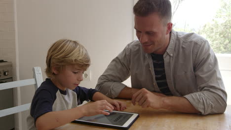 Padre-E-Hijo-Con-Tablet-PC-En-La-Mesa-De-La-Cocina,-Filmado-En-R3d