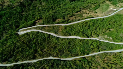 countryside road near flam, norway zigzags along a mountainside - tilt down rising aerial reveal