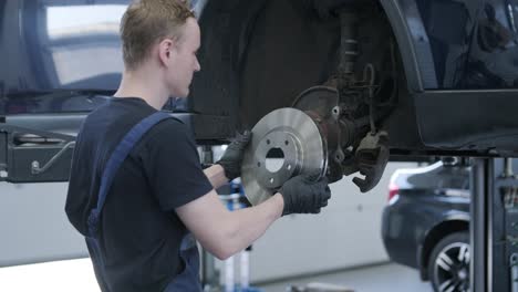 car mechanic working on brake disc replacement