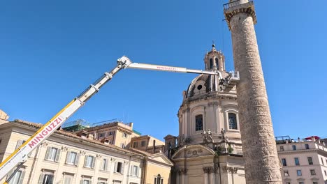 crane operating near historical column under clear sky