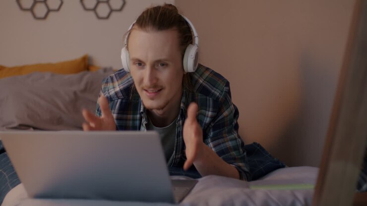 Homem em Videochamada no Laptop na Cama