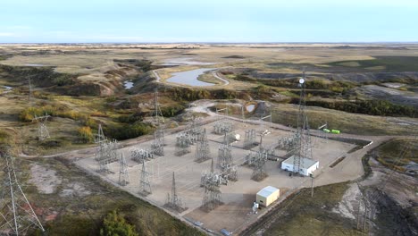 4k backwards flight over electricity masts and power lines in vast prairie setting