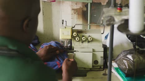 hombre africano cosiendo tejido