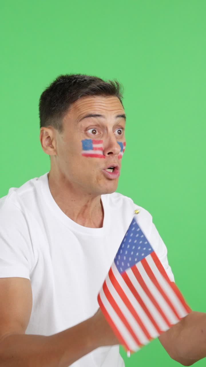 United States supporter screaming and waving a national flag looking away