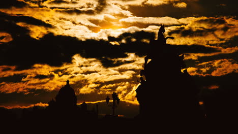silhouette of monument against dramatic sunset sky