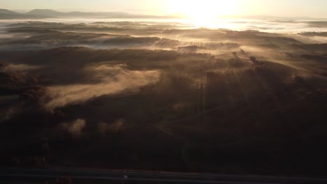 Die-Schönheit-Eines-Nebligen-Frühen-Sonnenaufgangs,-Wenn-Sonnenstrahlen-Durch-Den-Nebel-Dringen