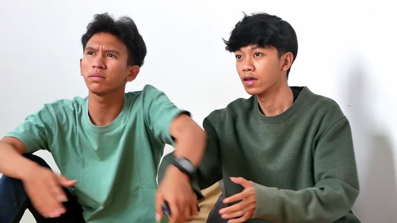 Two friends watching TV fighting over the TV remote control