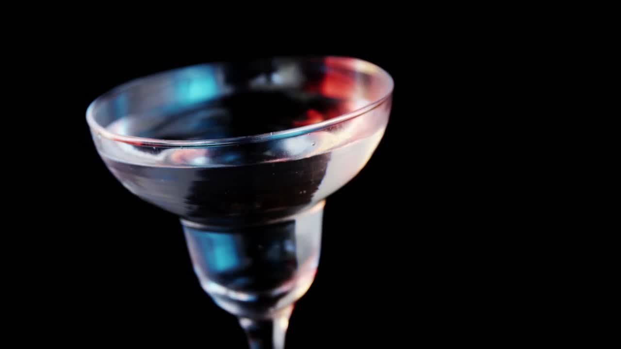 palito de oliva cayendo en el vaso de cóctel