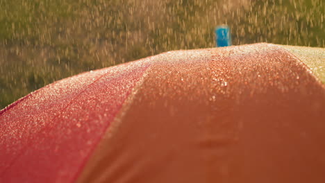 raindrops fall down on bright umbrella closeup stylish bright parasol protects owner from heavy rain