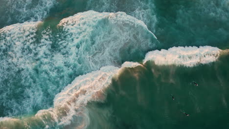 Vista-De-Pájaro-De-Los-Surfistas-En-La-Playa-De-Llandudno,-Ciudad-Del-Cabo,-Sudáfrica---Disparo-De-Drones