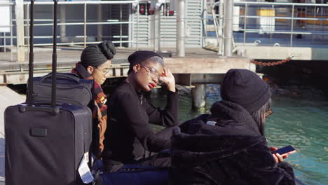 women waiting at the dock with luggage