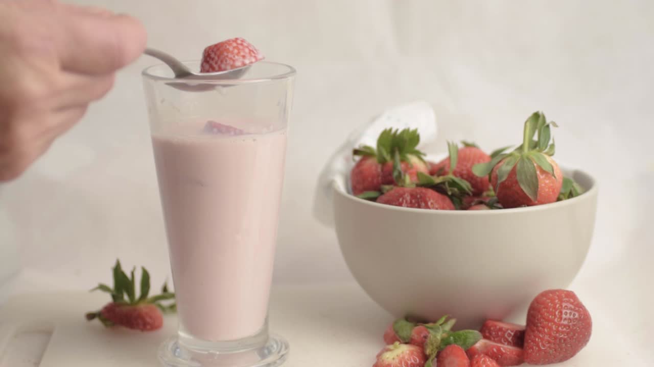 Inquadratura ampia di fragole mescolate e mangiate da un frappè con frutta fresca