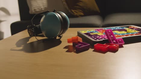 protectores para los oídos y rompecabezas de forma entrelazada en la mesa en casa para un niño diagnosticado con tea 3