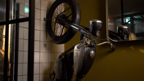 motorcycle stands vertically against the wall inside a restaurant