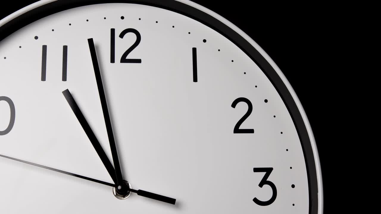 el lapso de tiempo, el reloj de pared blanco, la manilla larga señala el número once.