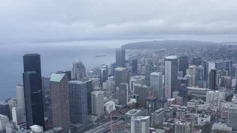 drone shot pulling away from seattle's downtown sector on a cloudy day