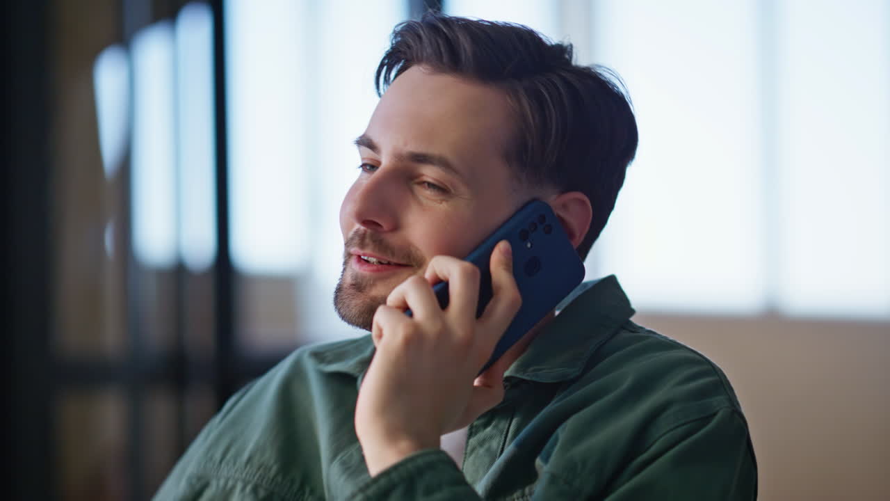 Emotional guy calling cellphone at home feeling relaxed closeup. Man chatting