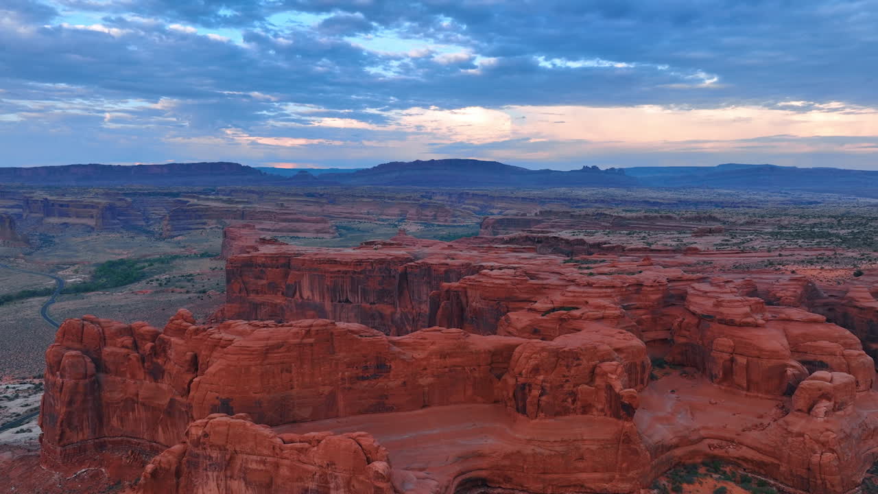 Rocce piatte con pareti scoscese nell'Arches National Park, Utah, USA. Cielo con nuvole suggestive. Vista aerea del deserto al crepuscolo