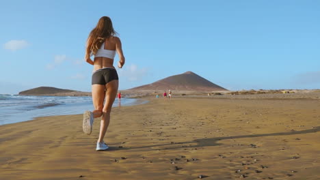 Sportlerin-Silhouette,-Die-Am-Strand-Läuft-Und-Wellen-Sprintet,-Die-Am-Morgen-Im-Hintergrund-In-Zeitlupe-Am-Meer-Abstürzen