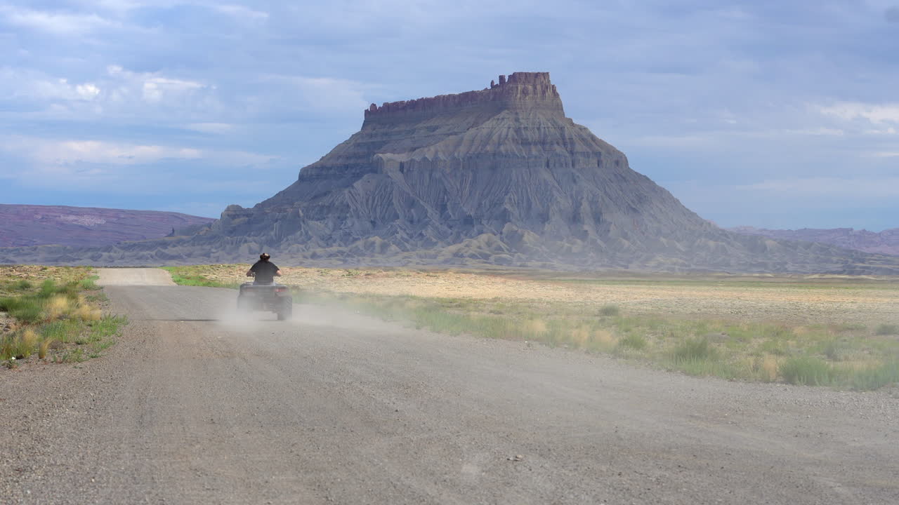 el hombre patina y se desliza montando un quad en una pista de tierra en factory butte, hanksville, utah, ee.uu.