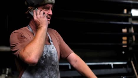 Blacksmith-talking-on-mobile-phone-4k