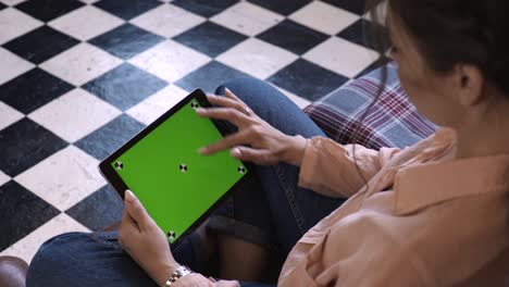 woman using a tablet with green screen