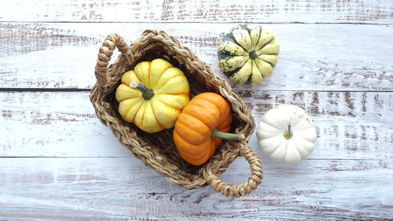 calabazas de otoño en la canasta en madera blanca