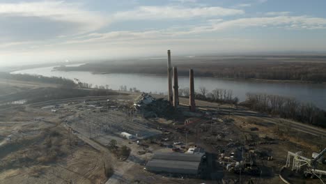 drone shot panning around smoke stacks next to the mississippi with a demolished coal power plant