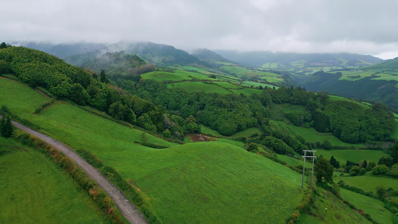 nubes de trueno que cubren las colinas verdes paisaje aéreo. montañas clima sombrío