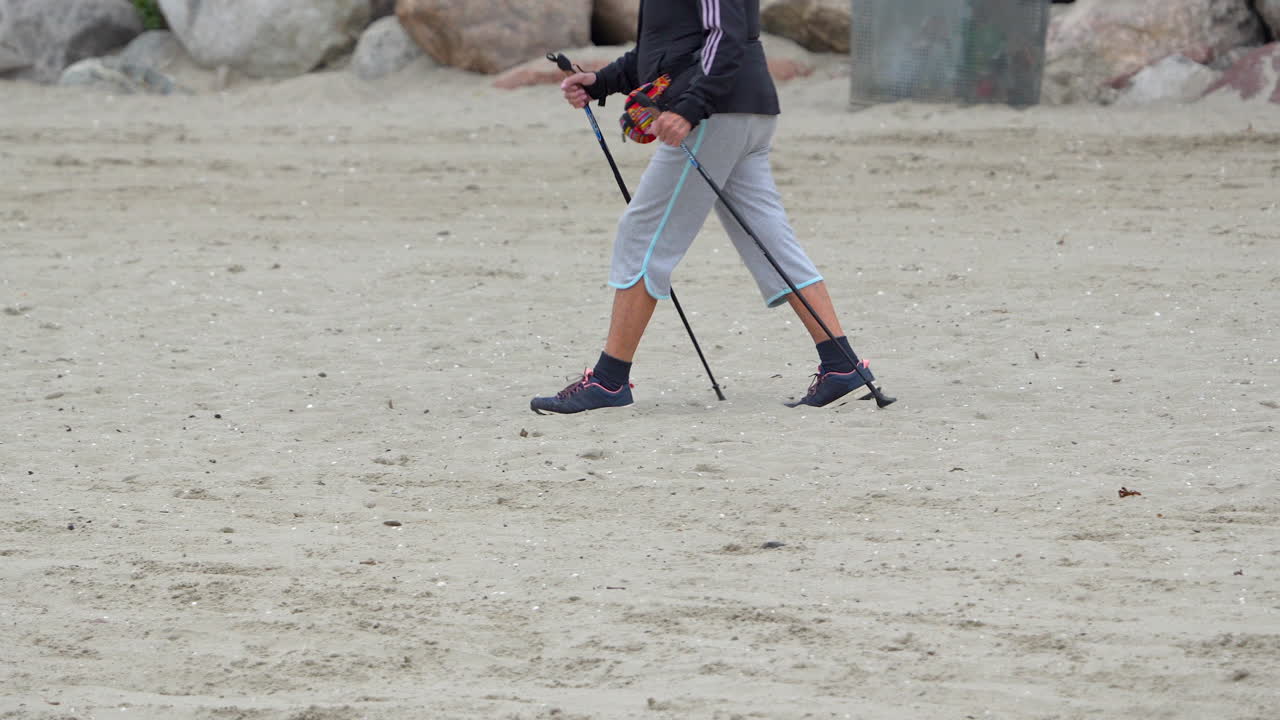 Cropped Portrait Of Person Walking On Sand Dunes With Trekking Poles