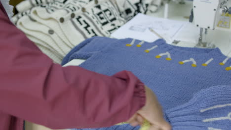 woman hands measure a handmade sweater made of wool