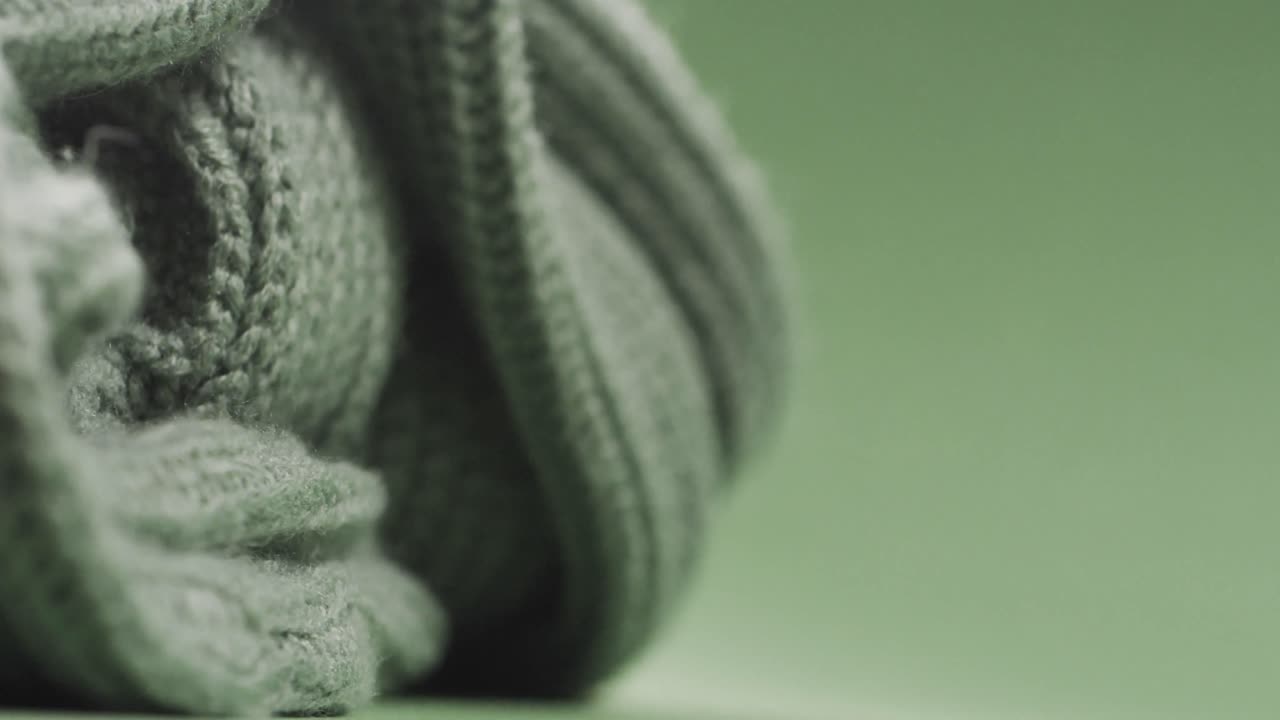 micro vídeo de primer plano de tela de ganchillo de lana verde con espacio de copia sobre un fondo verde