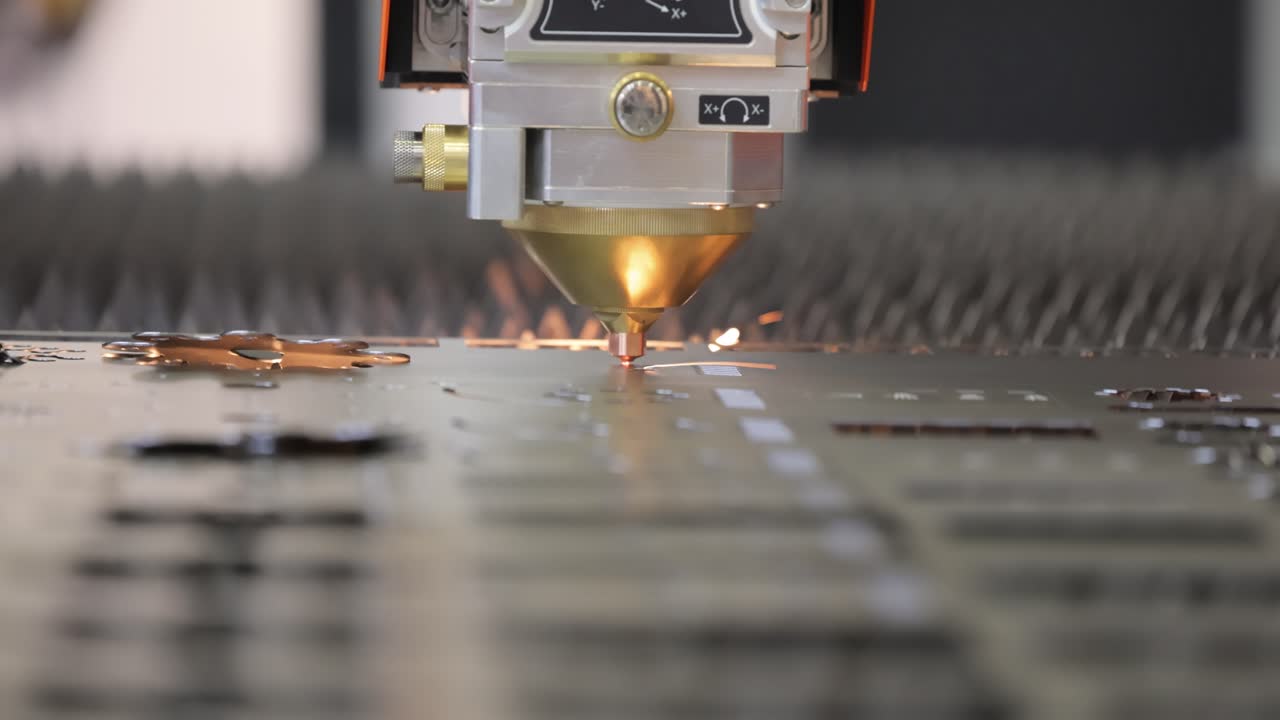 taglio laser cnc del metallo, moderna tecnologia industriale. piccola profondità di campo. avvertimento - ripresa autentica in condizioni difficili.