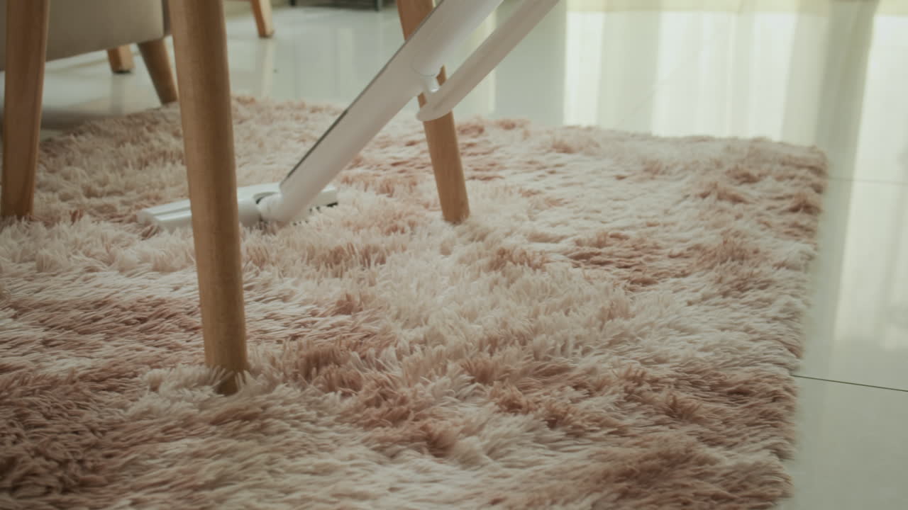 Persona che aspira la moquette in un soggiorno accogliente