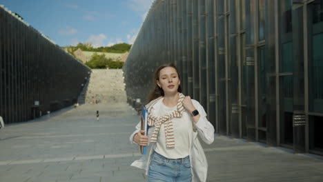 young female student late for school, watching time while running outdoor