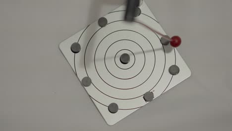 overhead shot of randomly oscillating magnetic pendulum in motion