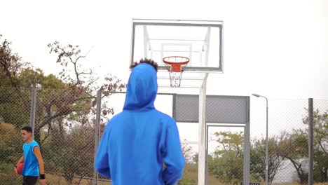 Young-african-american-playing-basketball-on-the-street-and-throwing-a-ball-to-the-basket-unsuccessfully.-Slow-Motion-shot