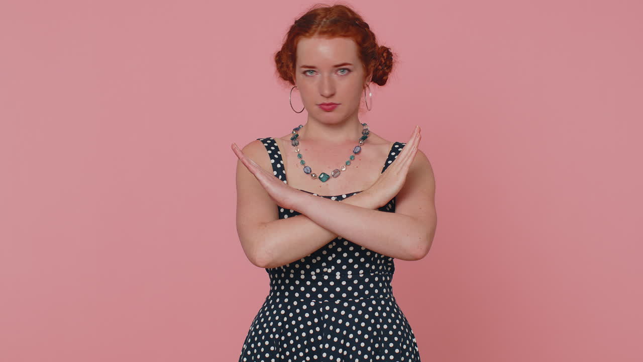 Girl say No, hold palm folded crossed hands in stop gesture, warning of finish, prohibited access