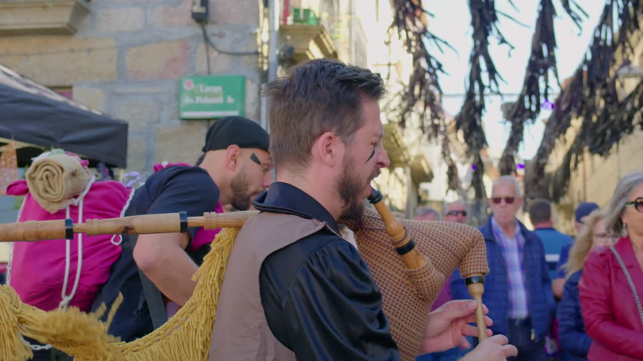 montalegre 13 september 2024 friday the 13th musician playing galician bagpipe in the village center crowd walking by