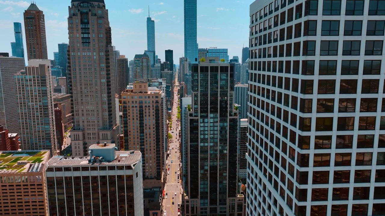 Vuelo sobre las fachadas de edificios de gran altura en el centro de Chicago, Illinois, EE. UU. Tomas sobre la larga calle recta que cruza la ciudad. Vista aérea