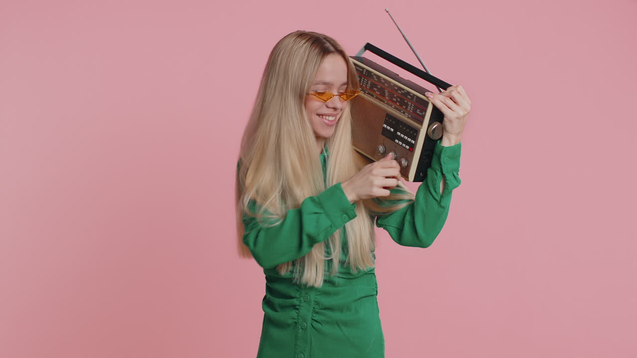 Happy girl using retro tape record player to listen music disco dancing of favorite track having fun