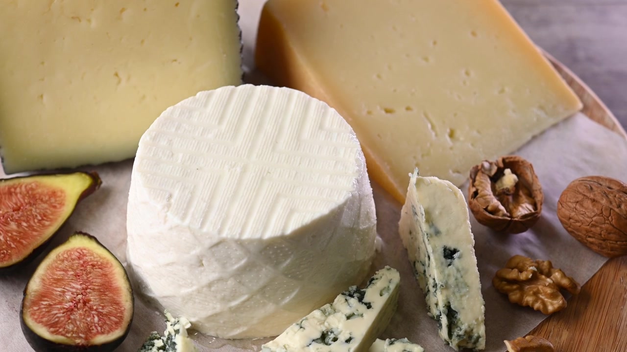 Assortimento di spicchi di formaggio, fichi freschi e noci che ruotano