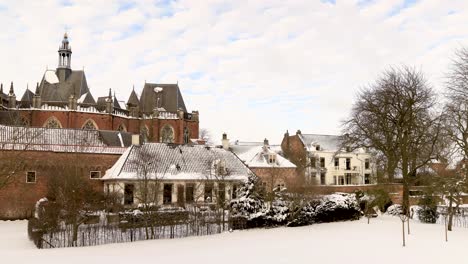Snowy-landscape-of-moving-time-lapse-showing-the-Walburgiskerk-of-Hanseatic-city-Zutphen-rising-above-the-historic-medieval-buildings-covered-in-snow-with-rising-tower-above