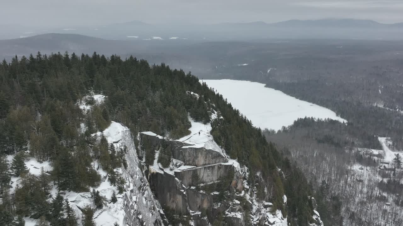 toma aérea del hombre en la cima de las montañas rocosas de invierno en quebec, canadá