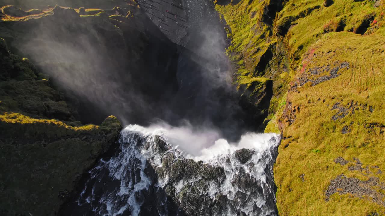 flotando sobre una gran cascada brumosa épica con agua que fluye hacia abajo, vista aérea de drones volando sobre la panorámica hacia abajo