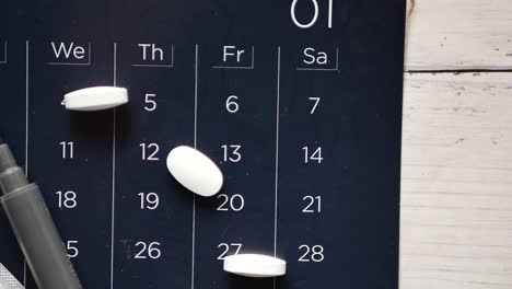 Top-view-of-pills-and-stethoscope-on-calendar